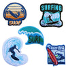 A collection of embroidered patches featuring surfing themes, including a sunset wave, a surfer silhouette, and a blue wave d