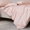 Luxuriöses rosa Bambus-Duvetcover-Set auf einem Bett drapiert.