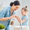 A woman is dispensing Farmhouse Highland Cow Soap into a hand of a young girl in a bathroom setting.