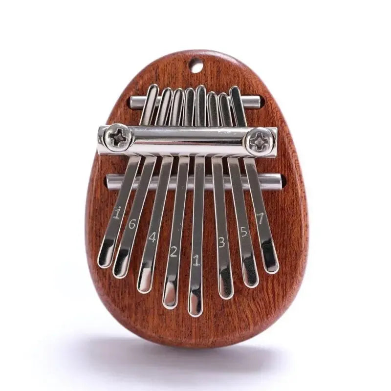 A wooden kalimba thumb piano with metal tines is shown, featuring a curved wooden body and a row of metal keys.