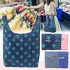 A dark blue reusable shopping bag with green stars is shown in a retail setting.