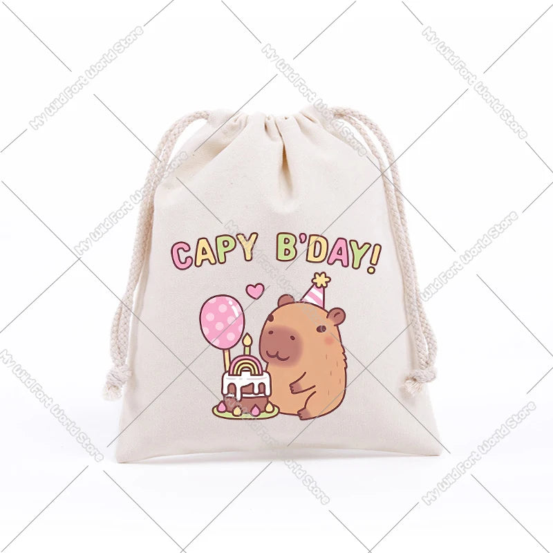 A beige drawstring storage bag featuring a cute capybara birthday design with a pink cake and party hat.