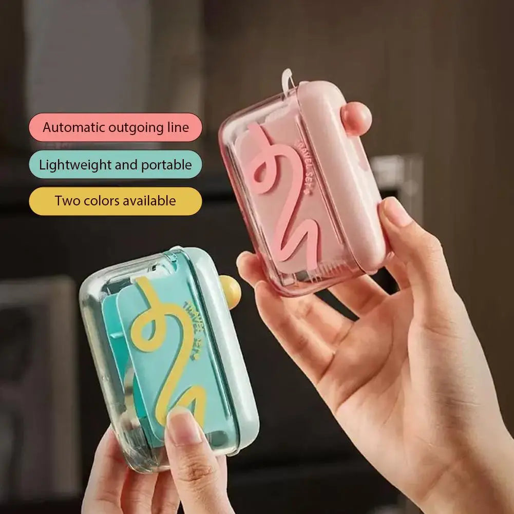 A hand holds a pink portable automatic floss pick dispenser with a swirling design and a light green version.