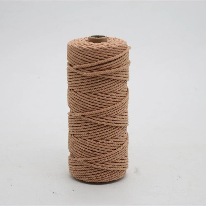 A spool of light tan macrame cord, 3mm/4mm thickness, used for crafting.