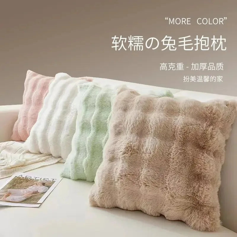A collection of fluffy, textured decorative pillow covers in various pastel shades displayed on a white surface.