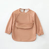 A light beige waterproof long-sleeve smock for toddlers with a rounded neckline and patch pockets.