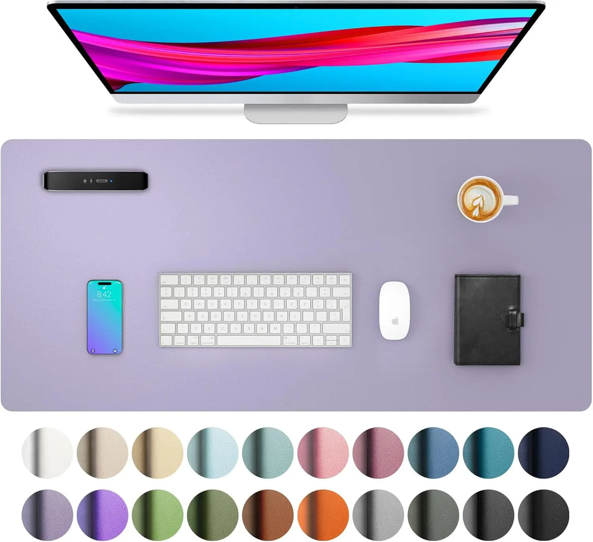 A computer monitor displaying colorful graphics is shown above a purple desk pad with various office accessories.