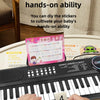 Hands are shown playing a 37-key electronic piano with a microphone, demonstrating the use of DIY key stickers for baby exerc