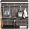 Adjustable stainless steel tension shower curtain rod mounted in a kitchen cabinet for hanging tools and items.