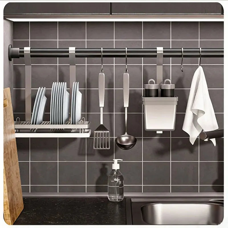 Adjustable stainless steel tension shower curtain rod mounted in a kitchen cabinet for hanging tools and items.