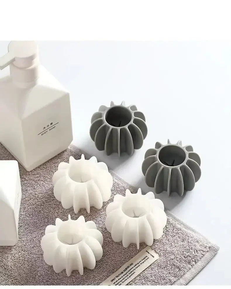 A collection of reusable laundry balls in white and gray for pet hair and lint removal.