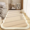 A plush beige decorative area rug with subtle striped shadows is placed on a light wood floor.