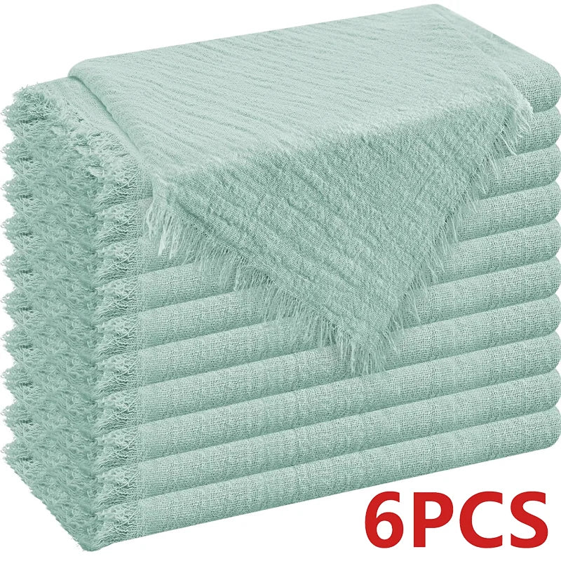 A stack of six light mint green raw-edge polyester cloth napkins.