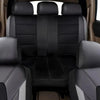 Interior view of a car with black leather seat covers and a front seat showing a gray and white accent.