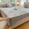 A luxury faux fur fitted sheet and pillowcase set displayed on a bed with white bedding and natural light.