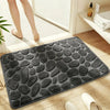 A dark gray plush non-slip absorbent bathroom rug with a pebble texture placed on a wooden floor.