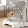 A clear, expandable pot and pan organizer rack with adjustable dividers sits in a white tray.