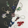 A collection of handcrafted rhinestone bag charms featuring sequin octopus and turtle pendants on gold-colored chains.