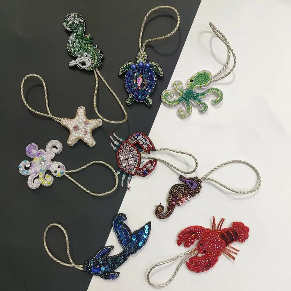 A collection of handcrafted rhinestone bag charms featuring sequin octopus and turtle pendants on gold-colored chains.