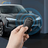 A hand holds a carbon fiber car key cover near the front light of a dark gray VW or Skoda vehicle.
