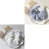 A close-up of a light blue plush coil hair tie for women resting in a white dish.