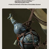 A dark blue ceramic gourd wine set with a net bag is suspended by twine against a dark background.