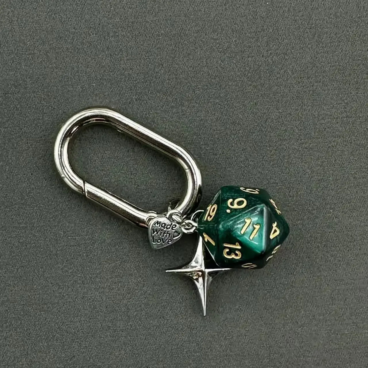 A silver D-shaped buckle keychain charm featuring a green dice with the number 13.
