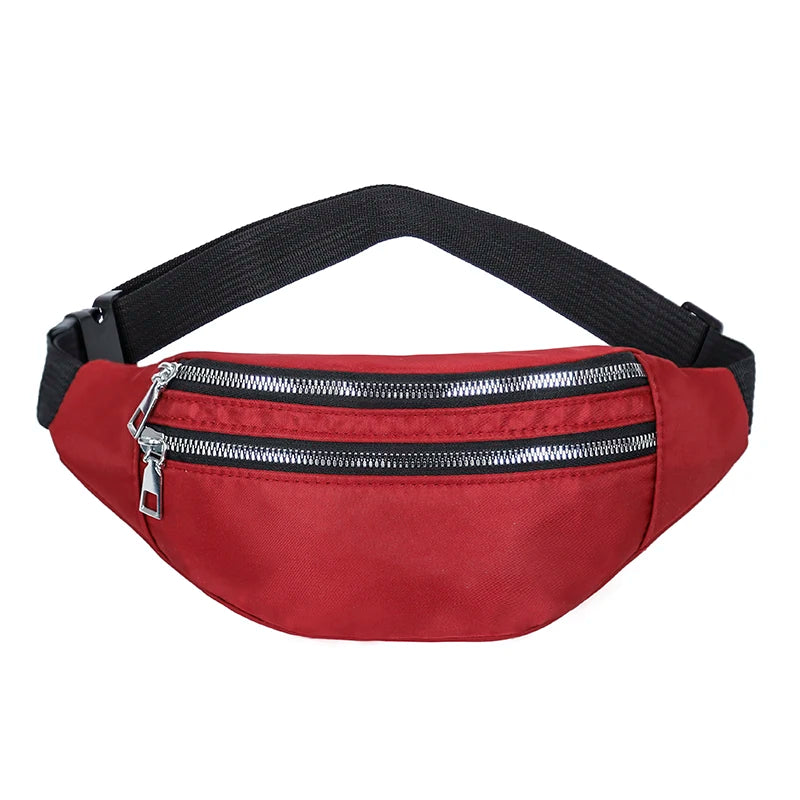 A red nylon waist pack with a black adjustable strap and a silver zipper.