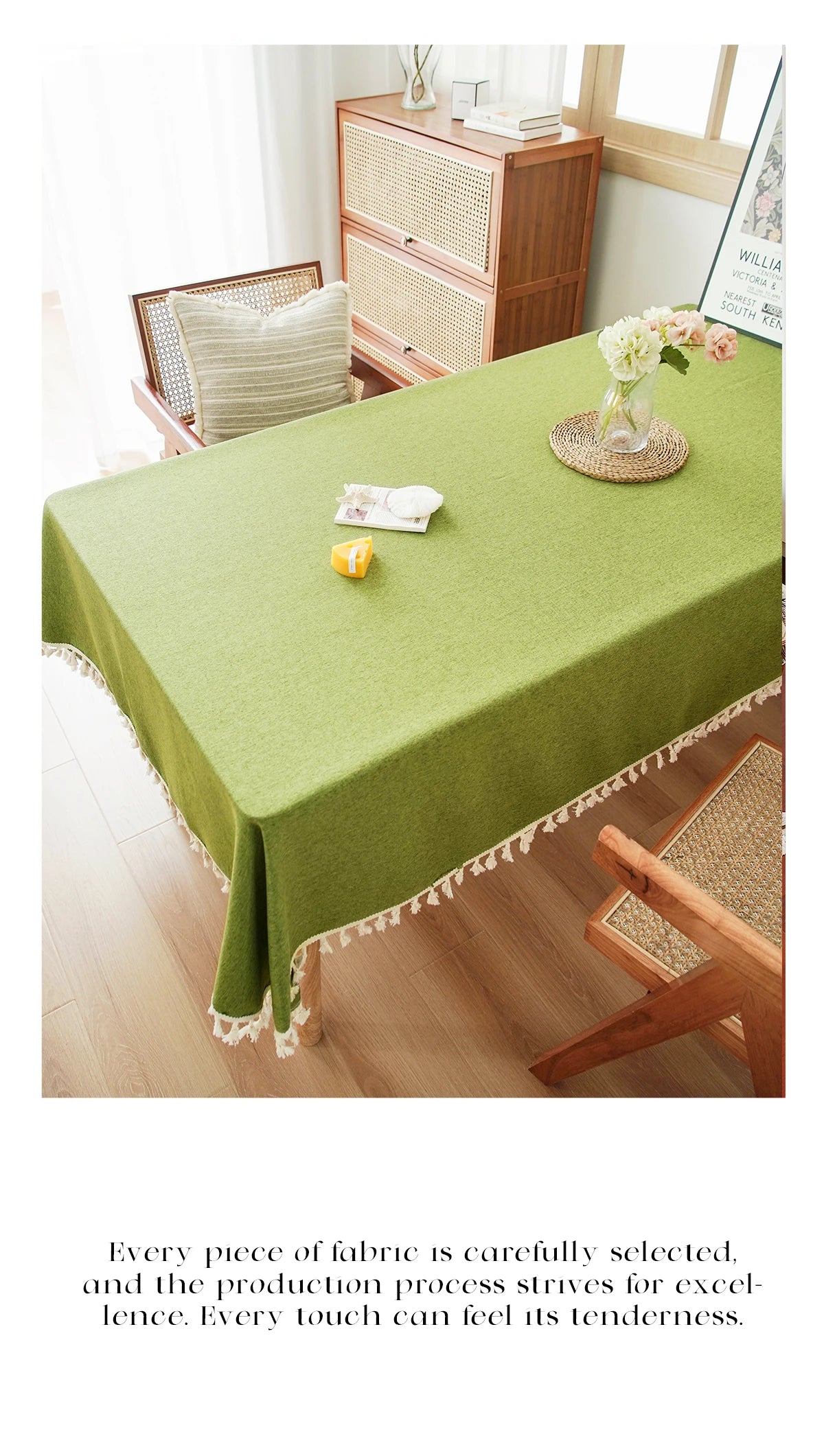 A lime green farmhouse tablecloth with white cotton tassels is displayed on a wooden dining table.