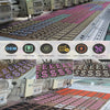 A close-up view of a production line featuring numerous rows of vintage chenille iron-on patches in various colors and design