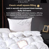 A white goose down comforter filled with a classic grid pattern, shown on a bed.
