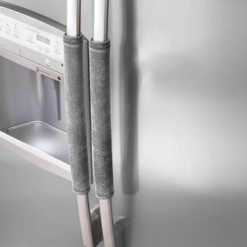 A close-up of a refrigerator handle with soft gray velvet anti-skid covers installed on the metal hardware.