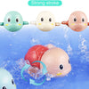 Three colored wind-up swimming turtle bath toys are shown floating in blue water.