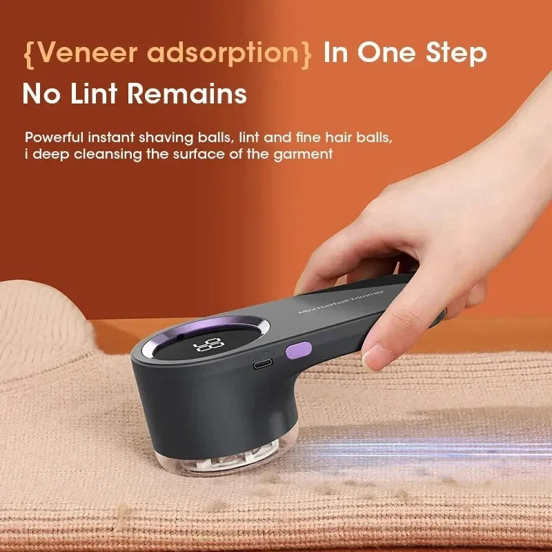 A hand holds a black electric lint remover device with a digital display, demonstrating its use on fabric.