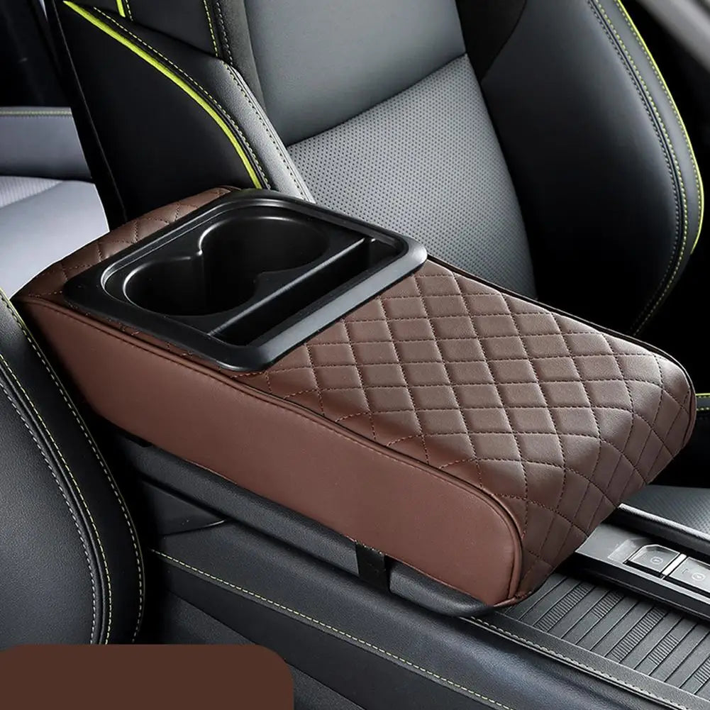 A brown quilted armrest cushion with a cup holder is shown in a car interior setting.