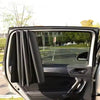 A close-up view of a dark magnetic car side window sun shade installed in a vehicle door frame.