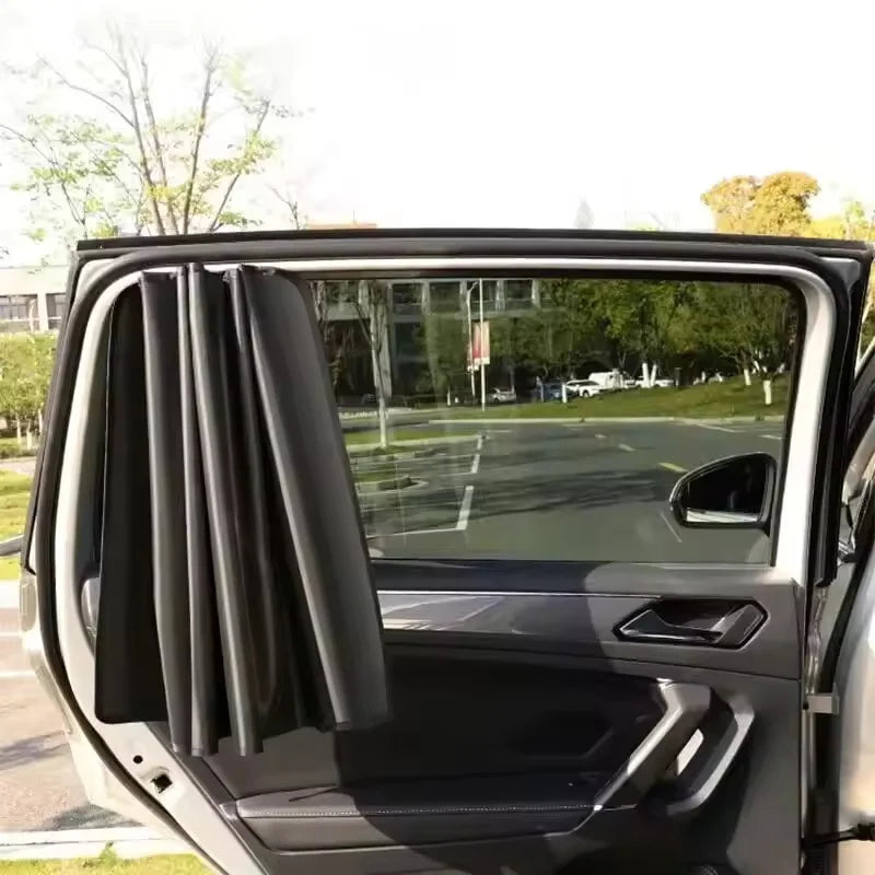 A close-up view of a dark magnetic car side window sun shade installed in a vehicle door frame.
