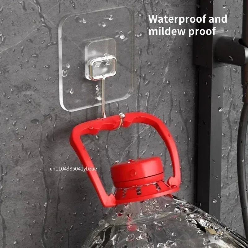 A red rotating wall hook is attached to a clear adhesive plate on a gray wall, used for storage.