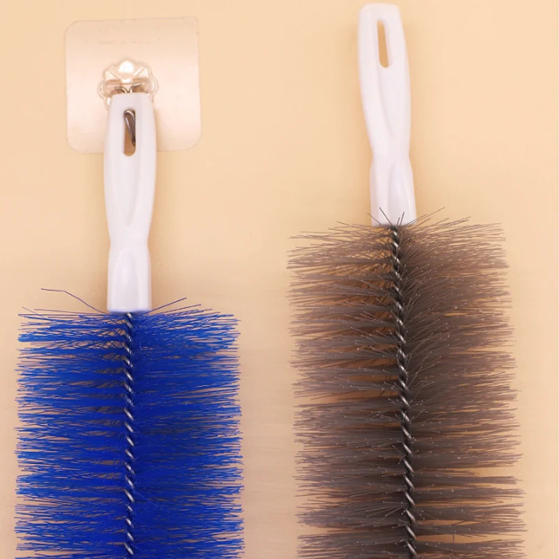 A white bendable fan duster brush with a long handle and a dark brown bristled head is shown.