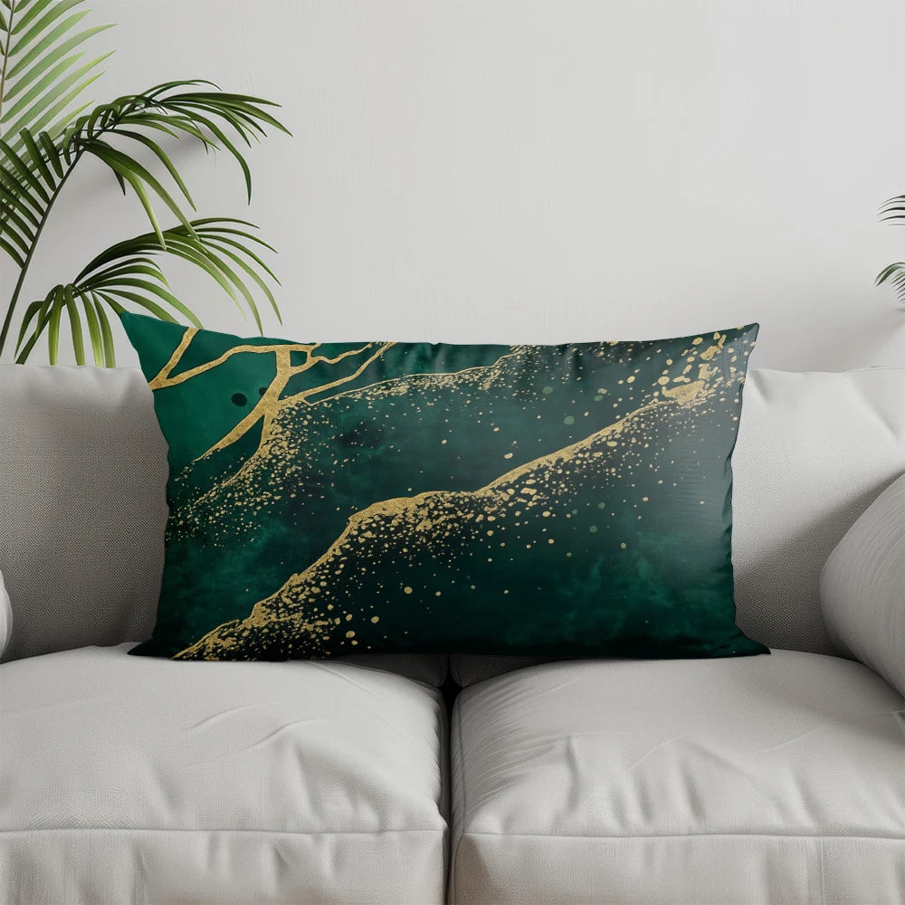 A decorative pillow featuring a dark teal background with gold leaf accents depicting a landscape.