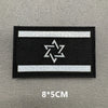 A black rectangular patch with a white horizontal stripe and a white star design on it.