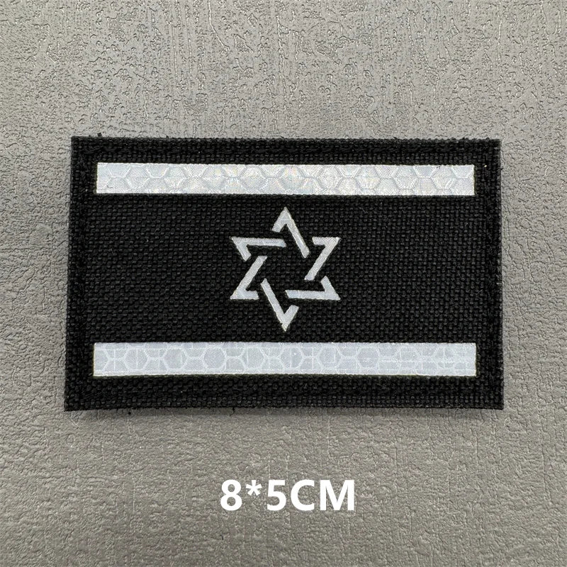 A black rectangular patch with a white horizontal stripe and a white star design on it.