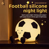 A glowing yellow football silicone night light resting on a dark surface.