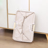 A beige foldable waterproof laundry basket with handles is shown on a wooden floor.
