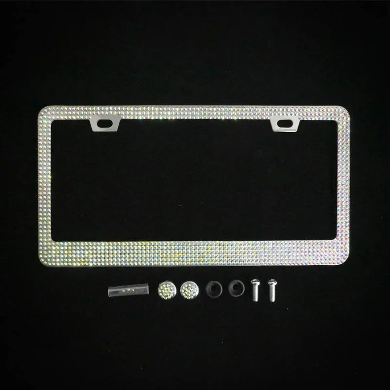A rectangular crystal rhinestone license plate frame with mounting tabs and two screw caps is shown on a black background.