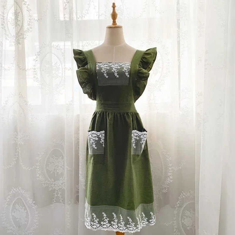 A green ruffled cotton linen kitchen apron with lace trim displayed on a mannequin.