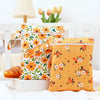 A pair of bright orange and white floral mini waterproof wet dry bags for baby are displayed on a white surface.