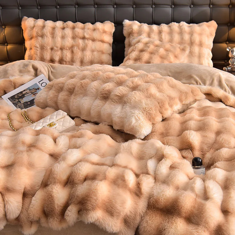 A set of four ultra-soft plush bedding items in a warm beige color displayed on a bed.