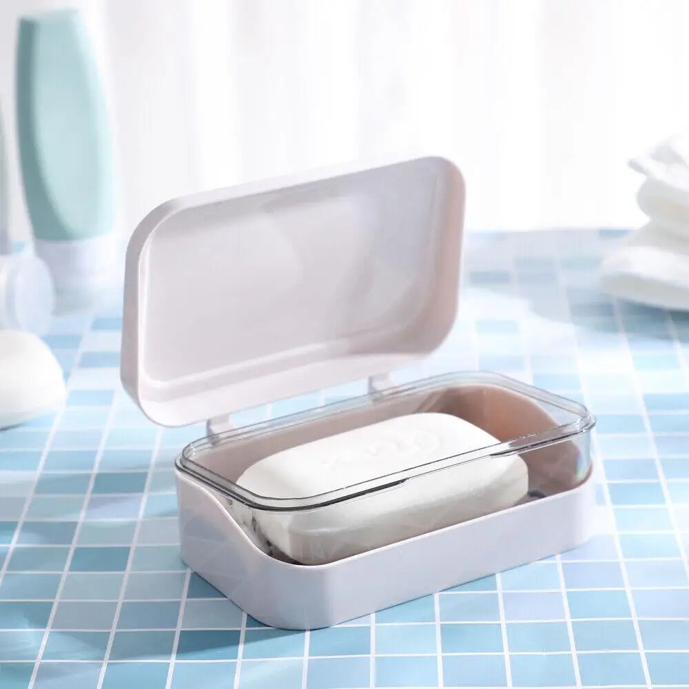 A white transparent soap dish with a drainage tray is shown on a blue checkered surface.