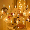 Warm white LED photo clip string lights with various photos hanging in a display